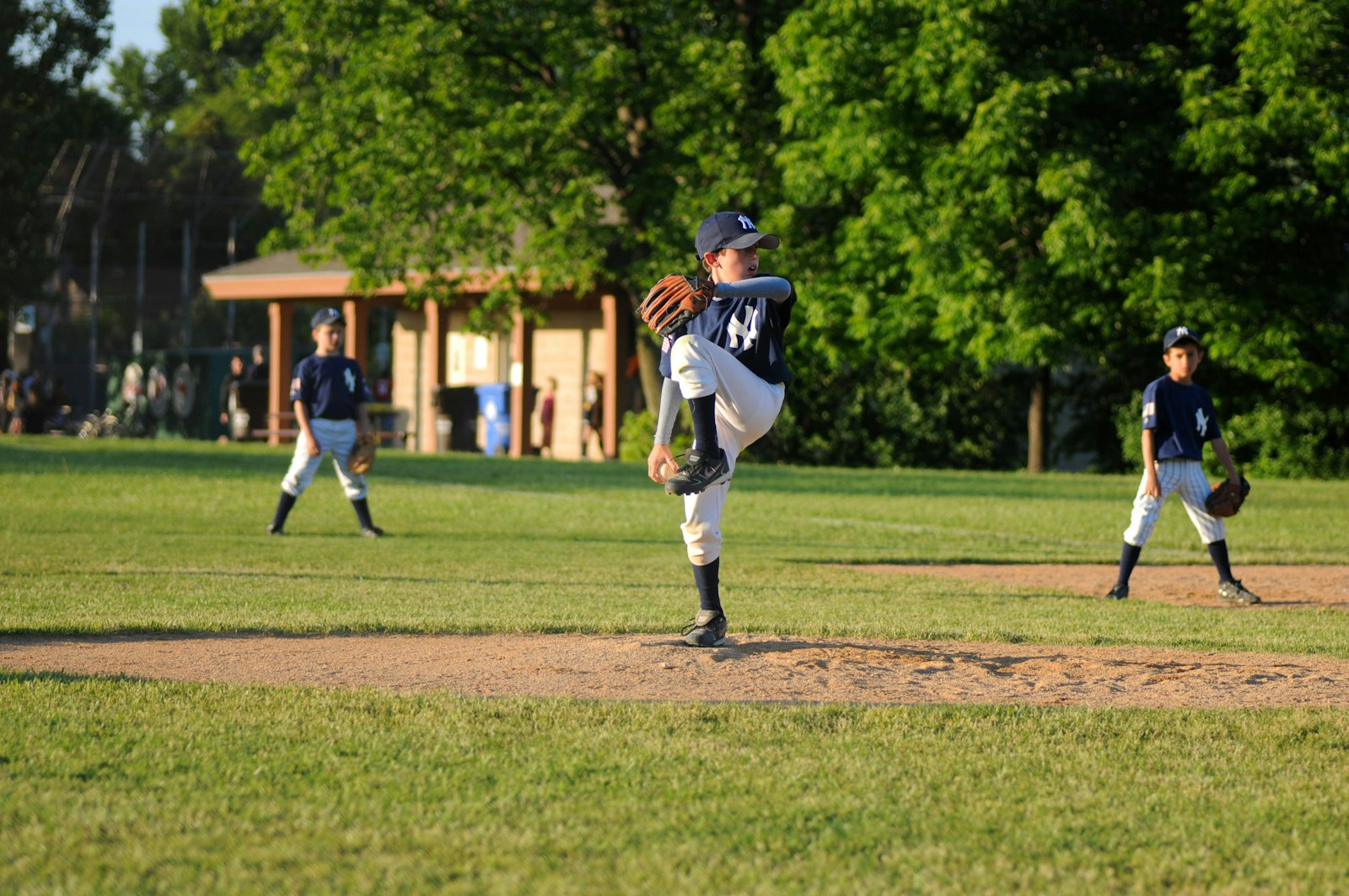 Young baseball pitcher preparing to throw on a sunny field